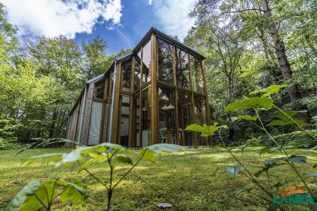 Een moderne versie van een oldambsterboerderij die in de natuur staat.