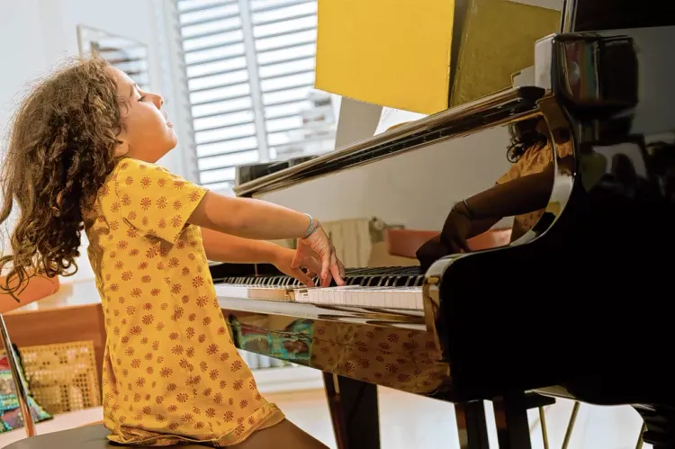 een meisje achter de piano