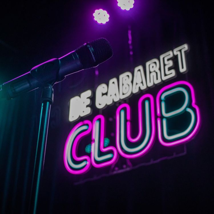 Verlichte letters van de cabaret club met op de voorgrond een microfoon.