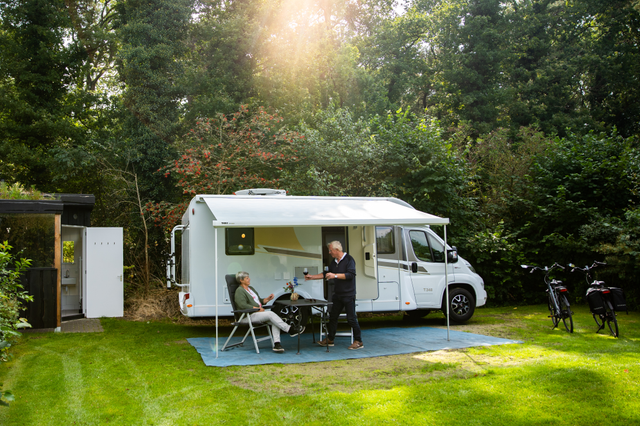 Ein älteres Paar sitzt vor seinem Wohnmobil auf einem Campingplatz in Drenthe.