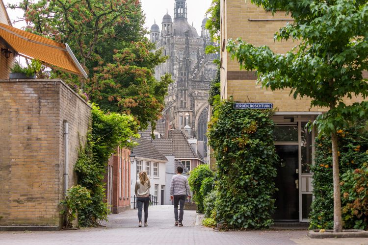 Stel wandelt in Den Bosch of 's-Hertogenbosch met St. Jans Kathedraal op de achtergrond