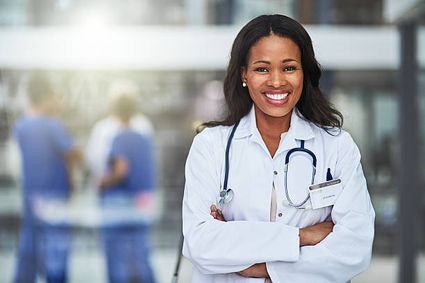 a woman doctor standing and posing for a picture arms crossed