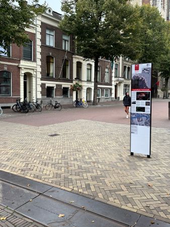 De stalen rand op het Domplein is een stukje zichtbaar, met een informatiebord van de Limes erbij.