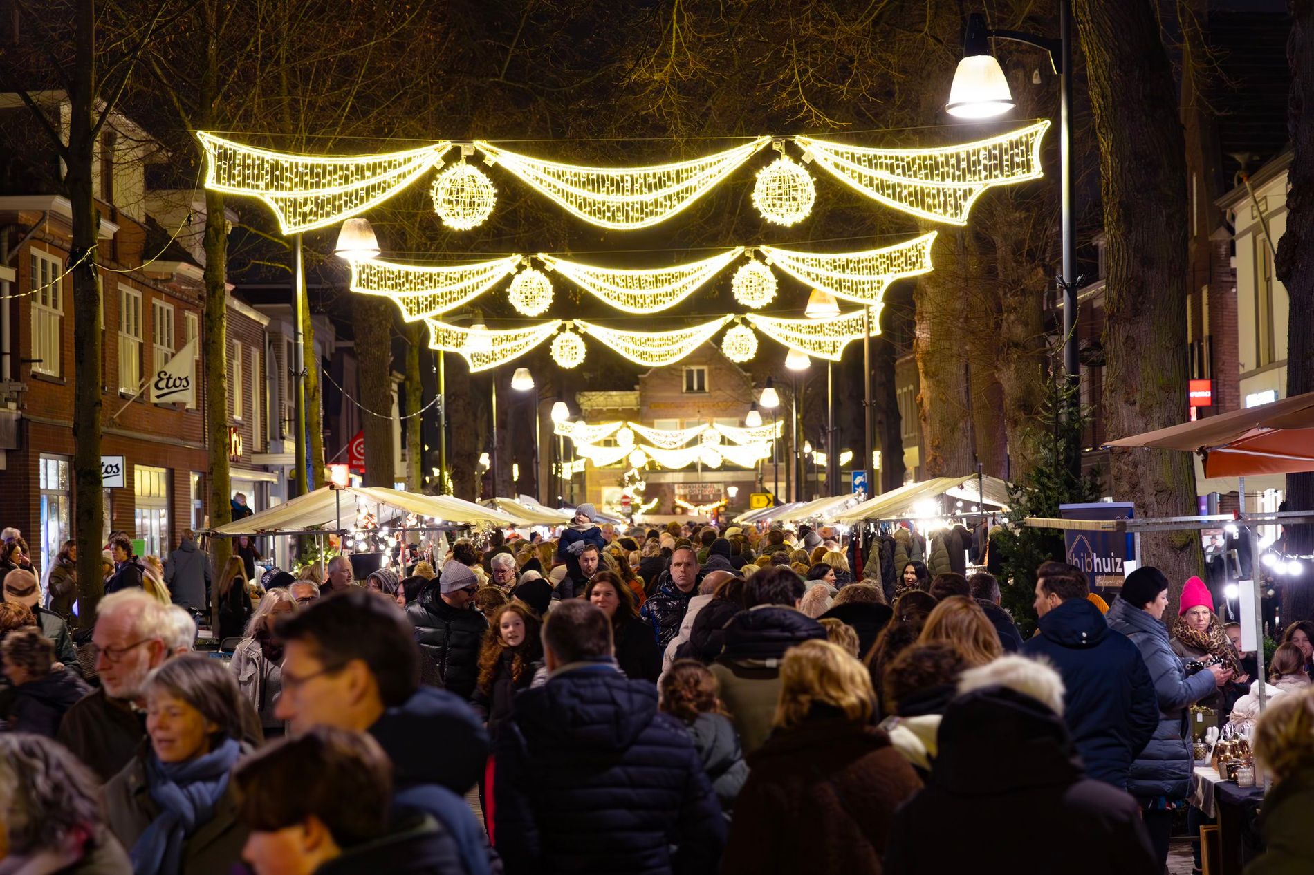 De verlichte Dorpsstraat in Oisterwijk met kramen en veel bezoekers.