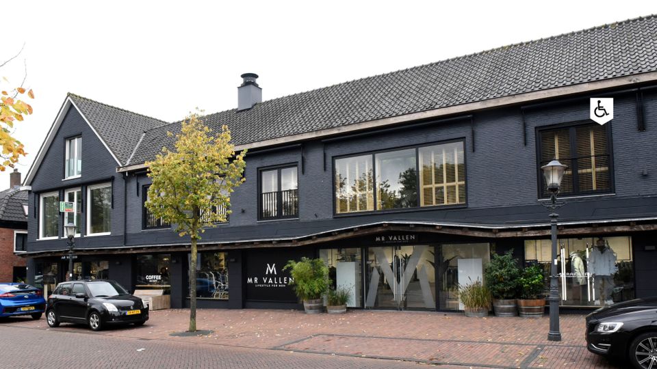 Kledingwinkel Vallen Mode Harmelen, provincie Utrecht, Groene Hart, moderne herenmodezaak met donkere gevel, etalages en entree aan de Dorpsstraat in het dorpscentrum.