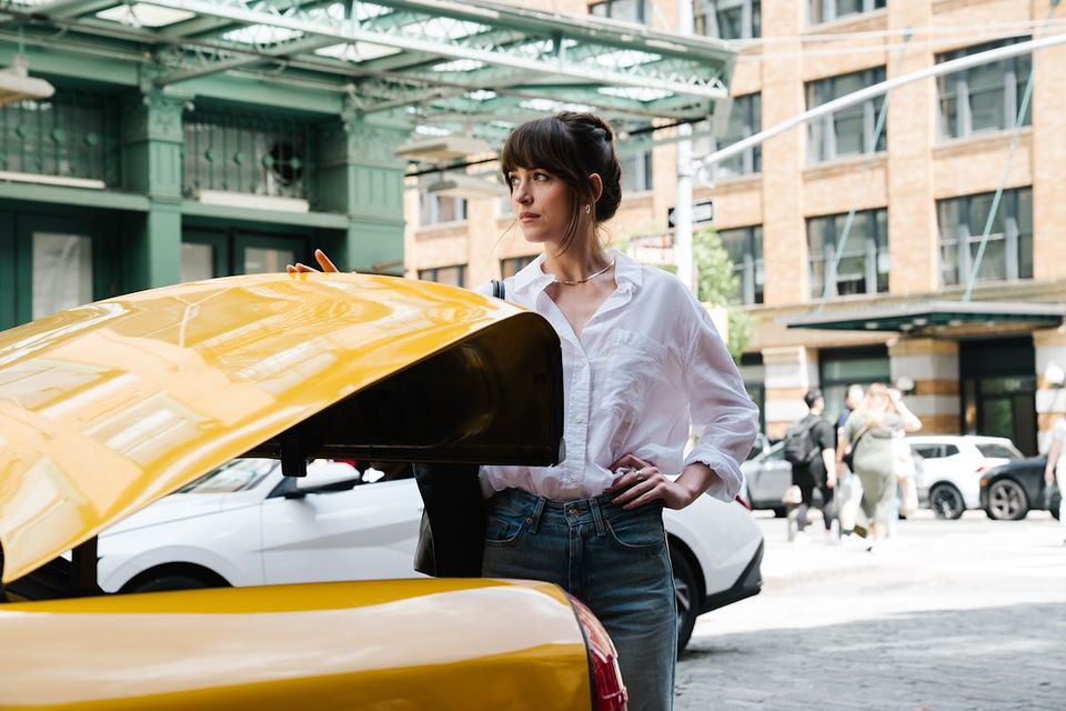 Een vrouw die de autoklep omhoog doet