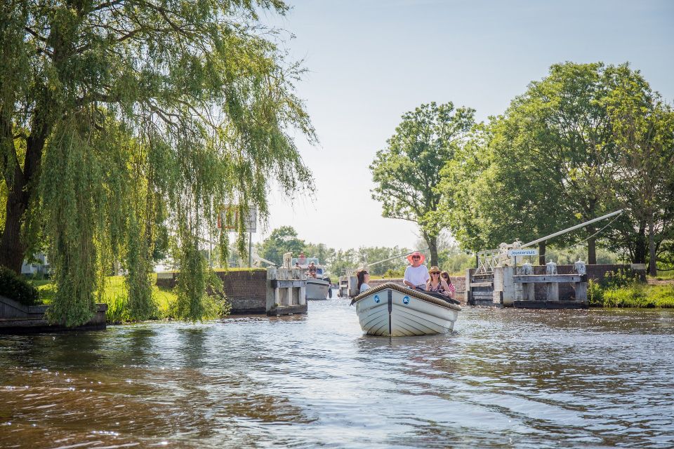 Een aantal vrouwen varen met een elektrische sloep door de oude sluis bij Joure.