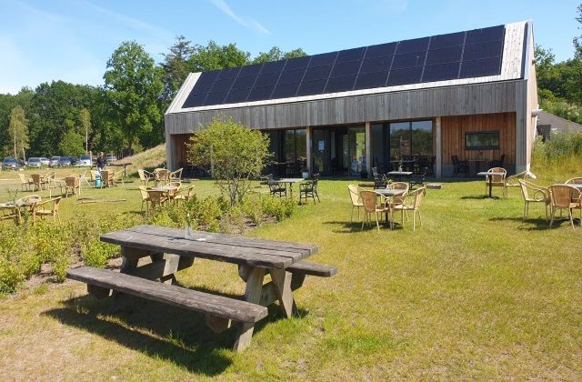 Het gebouw van Natuurplaats Noordsche Veld met op de voorgrond een terras.