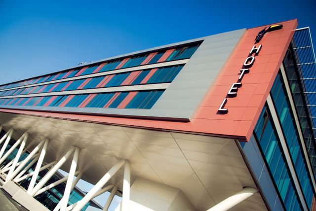 Moderne buitenkant van Van der Valk Hotel Veenendaal met de opvallende roodgrijze gevel en het hotellogo. Het hotel ligt in Veenendaal, aan de rand van regio De Utrechtse Heuvelrug.