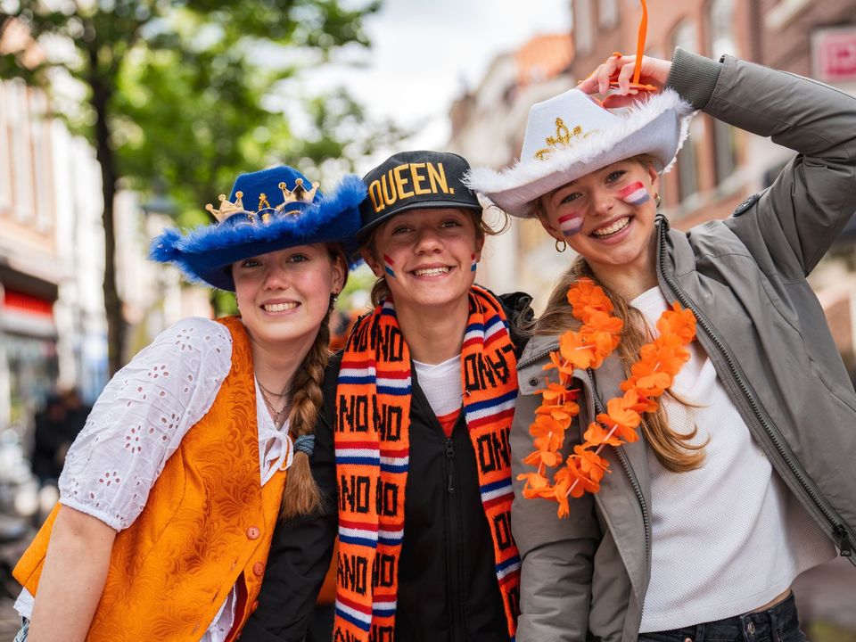 Drie jonge vrolijke meiden tijdens Koningsdag in Delft