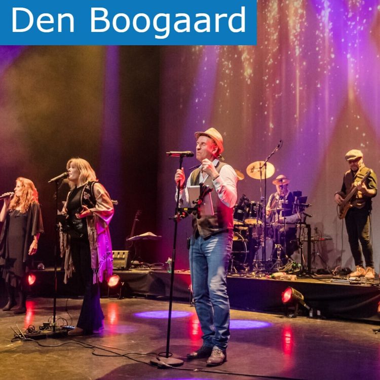 Vijfleden van de tribute band tijdens een optreden. Op de achtergrond zijn de drummer en gitarist te zien en op de voorgrond twee zangeressen en een zanger.