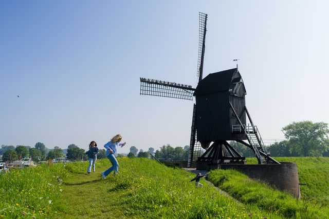 Twee kinderen rennen tijdens de spreekwoordenroute over de vestingwerken in Heusden.