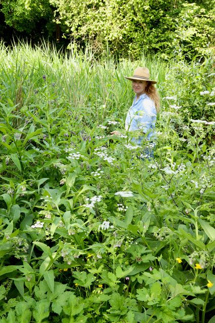 De gids van de Wildpluk wandeling staat in een weiland