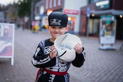 Jongetje met emmer vol snoep tijdens Halloween tocht in Gemert Centrum