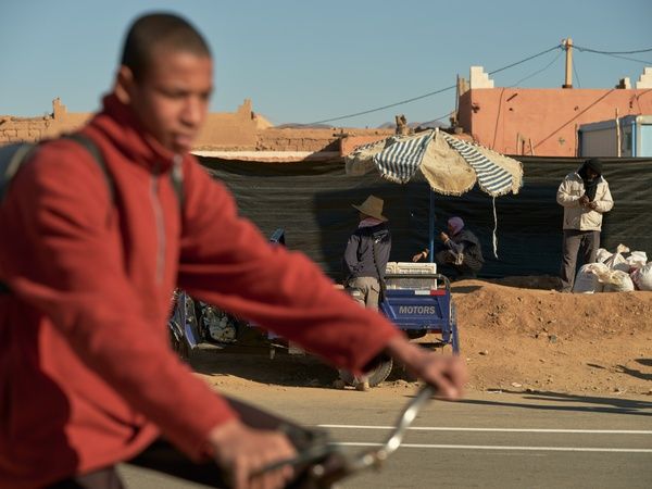 Man op fiets tegen achtergrond van werklieden in Arabisch land