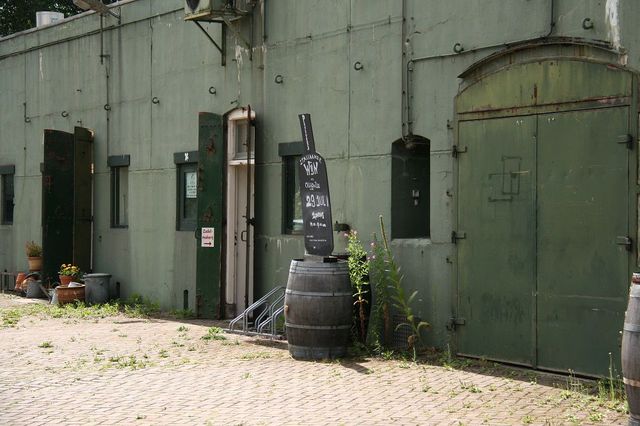 Een betonnen fort met groene luiken en twee krijtbordjes voor de deur.