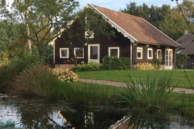 Appartement omringd door groen met een vijver voor de deur.