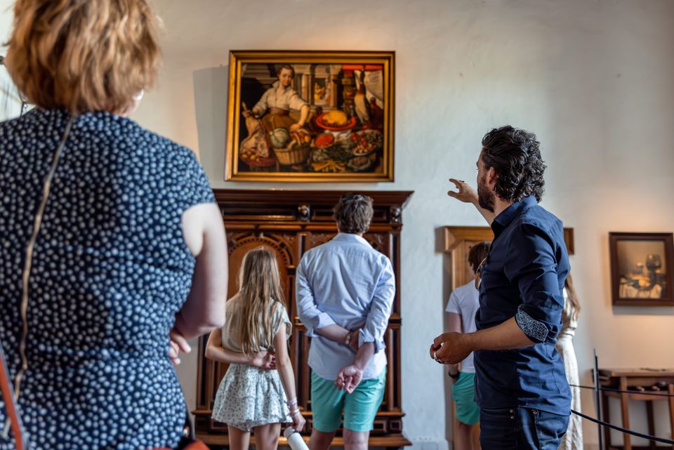 Bezoekers aan het Muiderslot bekijken de museumzaal