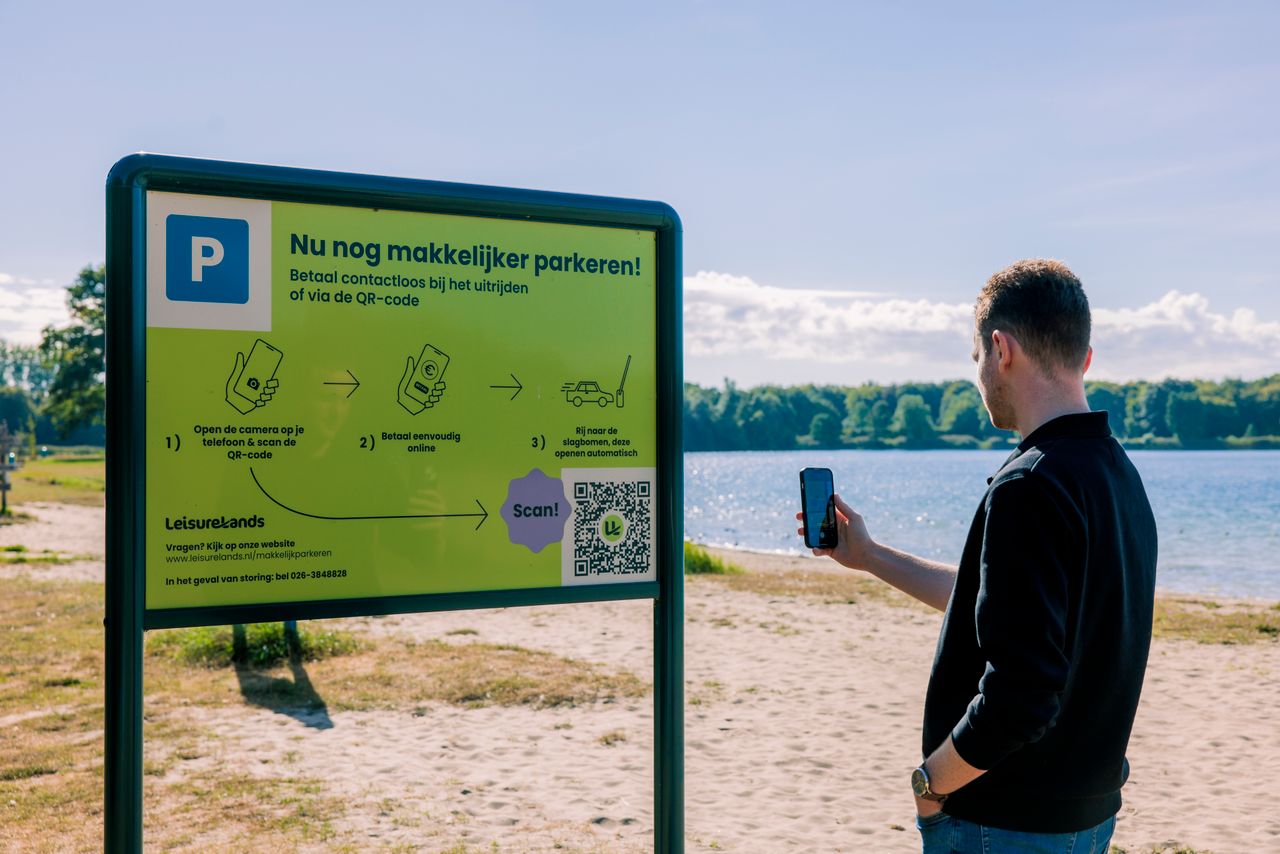 Jongen scant QR-code om uitrijkaartje te kopen.