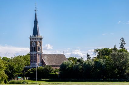 Sint Bonifatiuskerk in Cornwerd met een blauwe lucht.