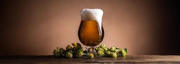 glas schuimend bier met hopbellen