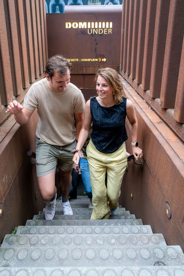 Bezoekers beklimmen de trappen van DOMunder op het Domplein.