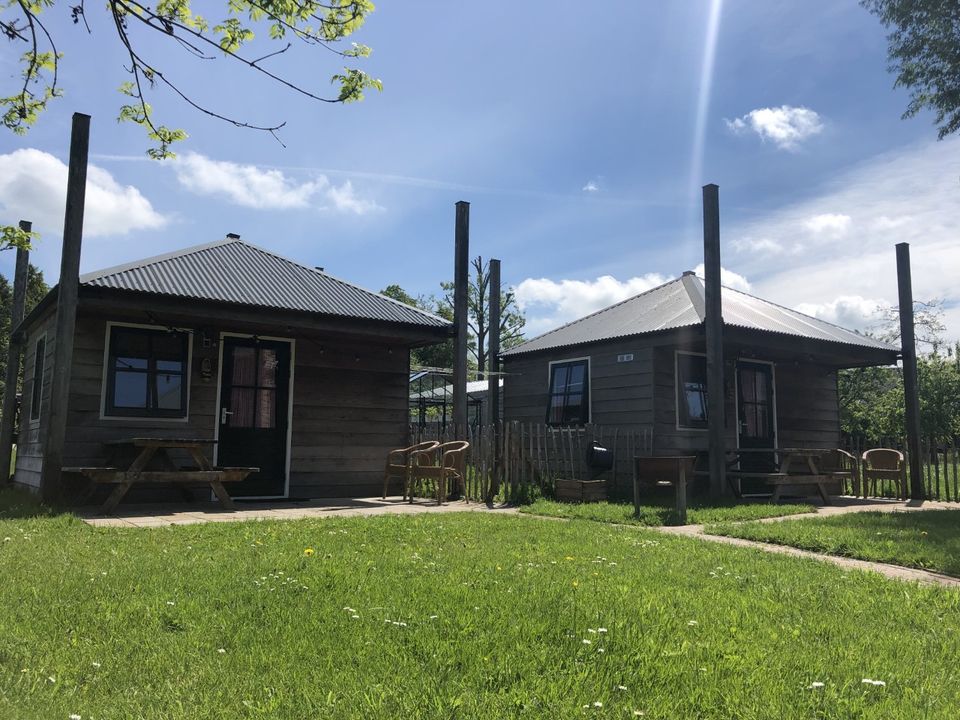 Verblijfsaccommodaties op de boerderij van BoerBert met houten huisjes in het groen, landelijke overnachtingsplek in het Groene Hart.