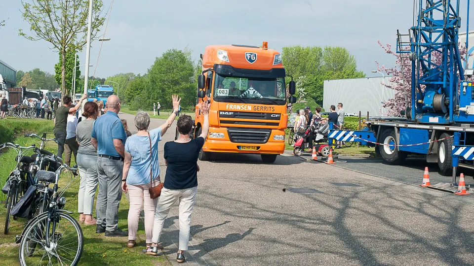 mensen zwaaien naar passerende trucks