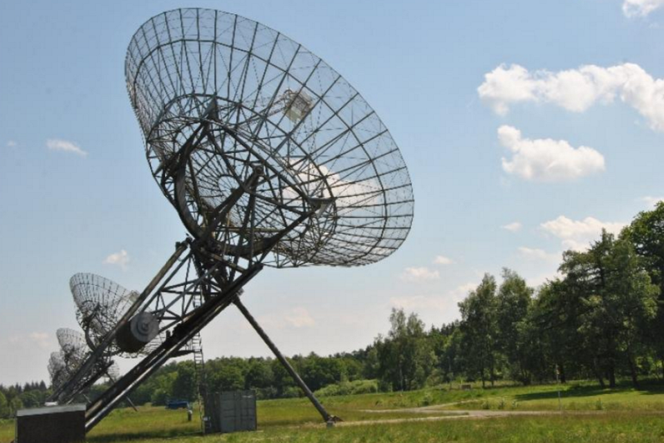 Een rij radiotelescopen in de natuur.