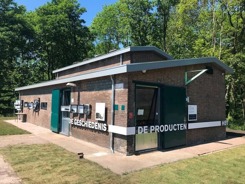Een bakstenen huisje met daarin museale objecten tentoongesteld.