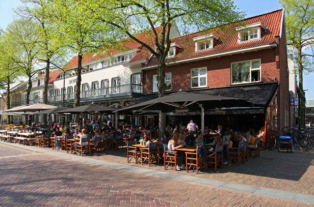 Het vooraanzicht van Eetcafé De Tijd met terras.