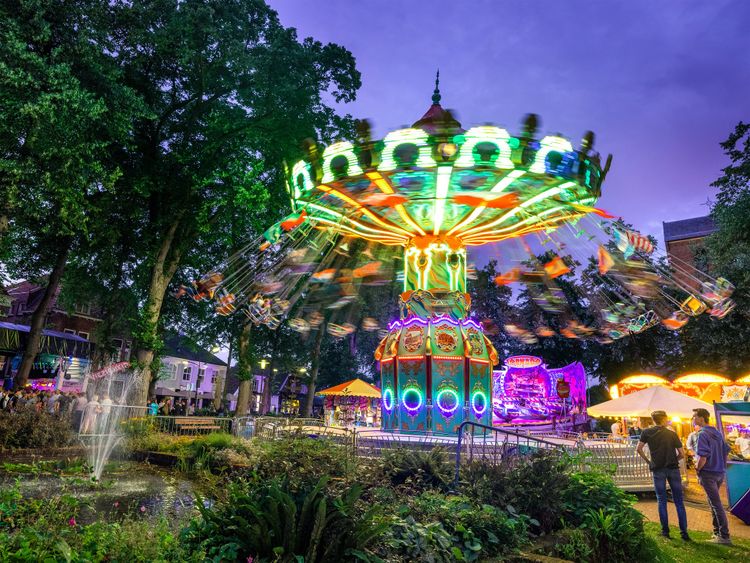 Mensen zwieren in een kermisattractie tijdens de avonduren