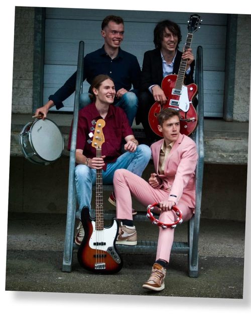 Bandleden zittend op en trap