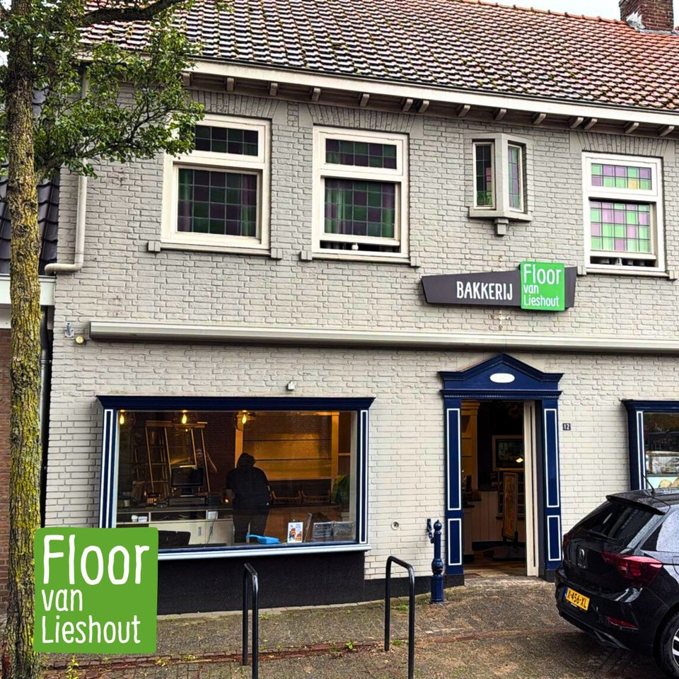 Witte gevel van het pand van Bakkerij Floor van Lieshout in Moergestel met groen met wit uithangbord