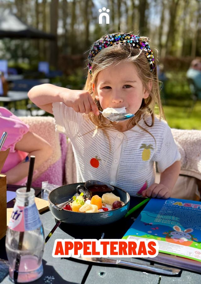 Kind die op het terras fruit eet