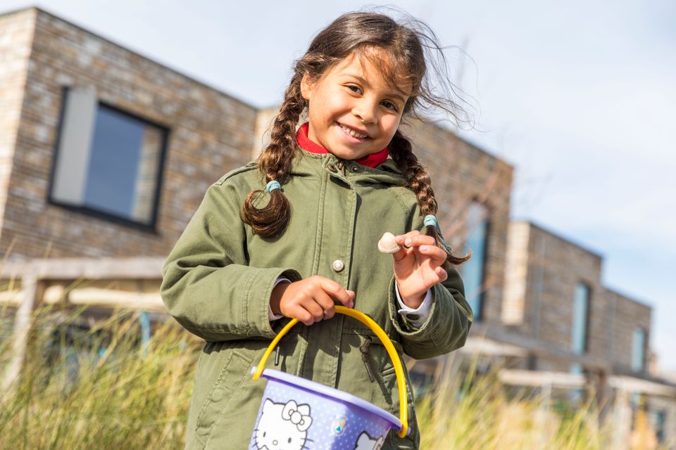 Meisje met een emmertje en schelp in haar handen in Almere Poort, Flevoland