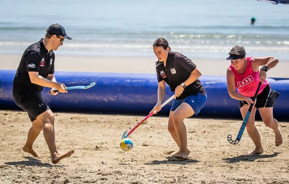 Mensen die beach hockey spelen