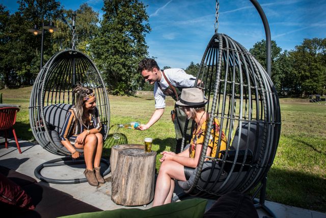 Twee vriendinnen zitten op hangstoelen op het terras van Fort aan de Buursteeg
