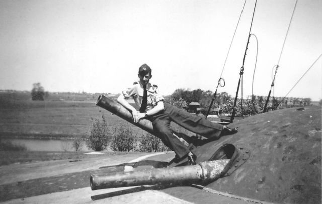 Een soldaat leunt op een kiekeboe-kanon.