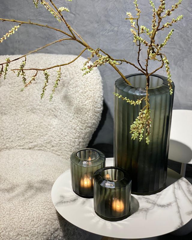 Een foto met een plant, kaarsjes en een stoel