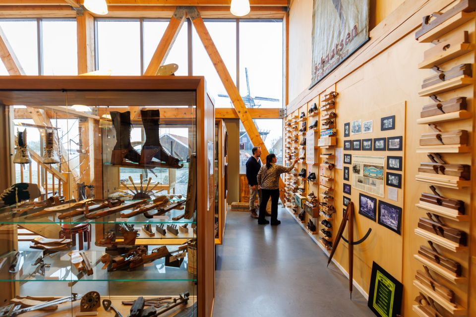 De collectie met verschillende voorwerpen bij Museum Houtstad IJlst met op de achtergrond twee bezoekers die aandachtig staan te kijken.