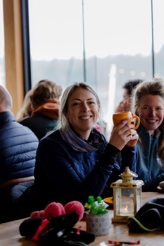 Vrouw met een kop warme chocolademelk in een restaurant.