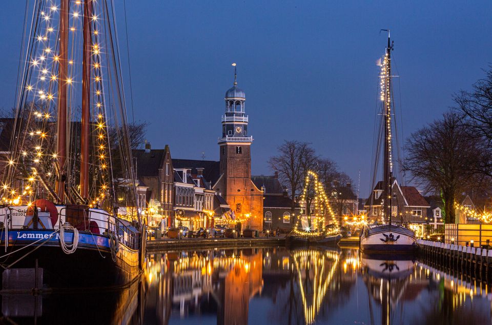 Een prachtig avondbeeld van belicht lemmer. De zeilen van de boten zitten vol met mooie gele sfeer-lichten.