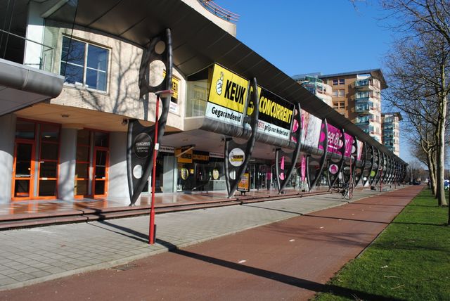 De buitenkant van het gebouw van Woonhart met logo's er op.