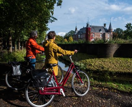 Fietsers stappen af en kijken uit over Slot Zuylen