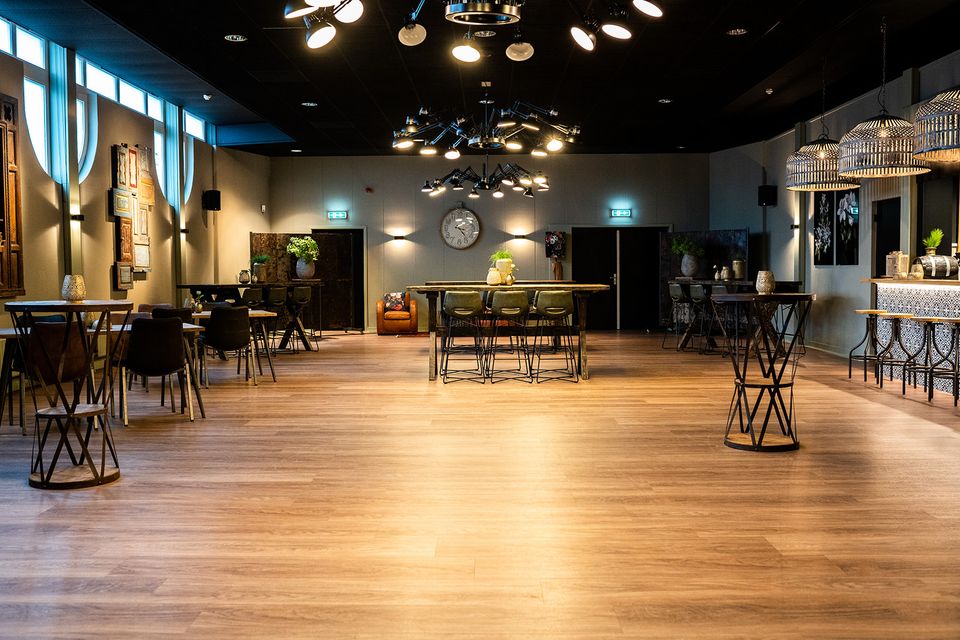 Ruime evenementenruimte van Plein 7 in Woerden met tafels en sfeerverlichting.