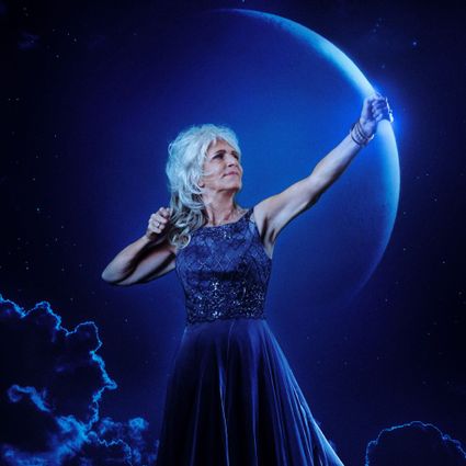 Photo of Leonie Jansen holding what looks like a bow and arrow in dark purple colors. The bow is a crescent moon.