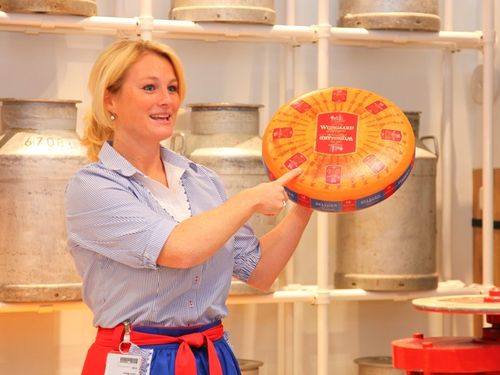 Een vrouw die een kaas vast heeft bij de Cheese Factory