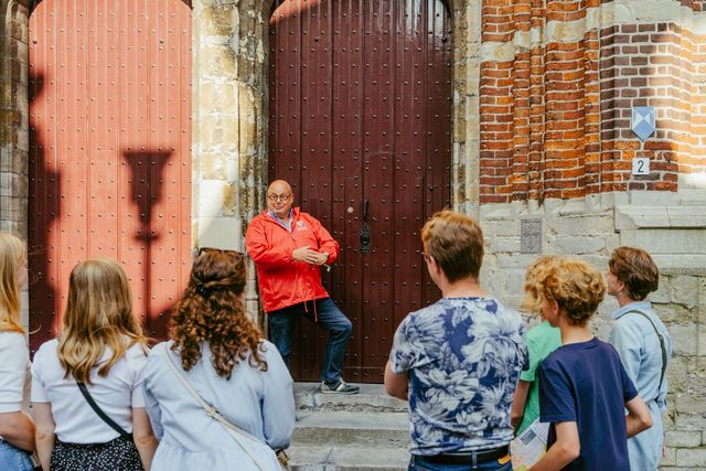 Gids die met groep de toren in gaat