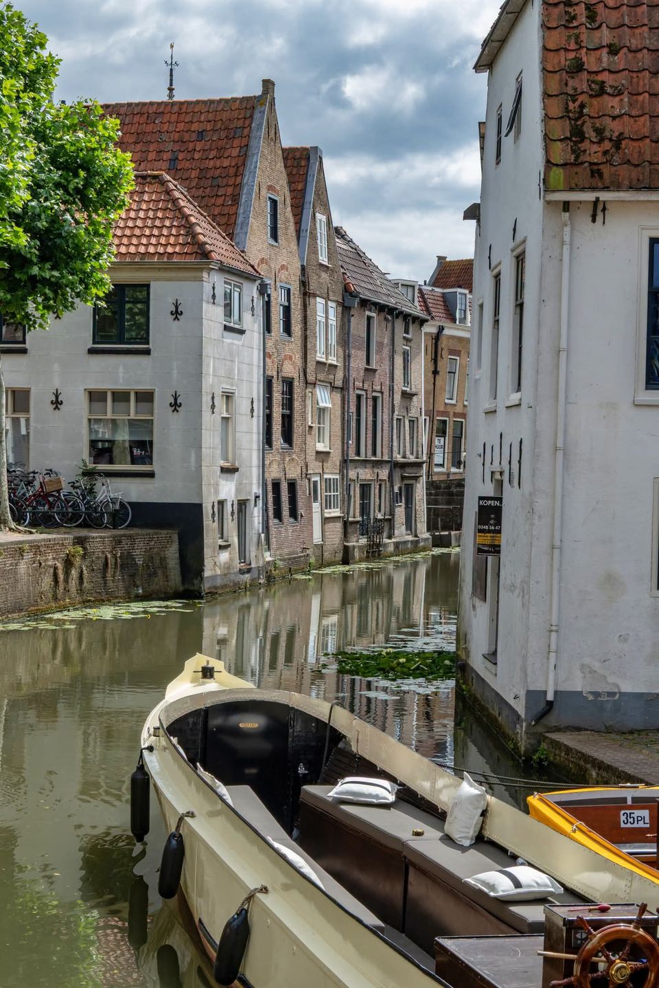 Historische gracht, Oudewater, Groene Hart, rondvaartboot aangemeerd langs karakteristieke grachtenpanden tijdens een stadswandeling door de historische binnenstad.